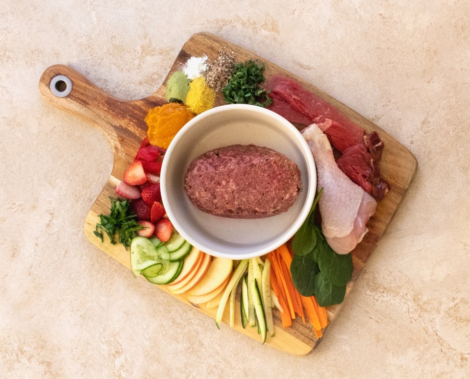 chopping board with fresh veggies and dg raw food